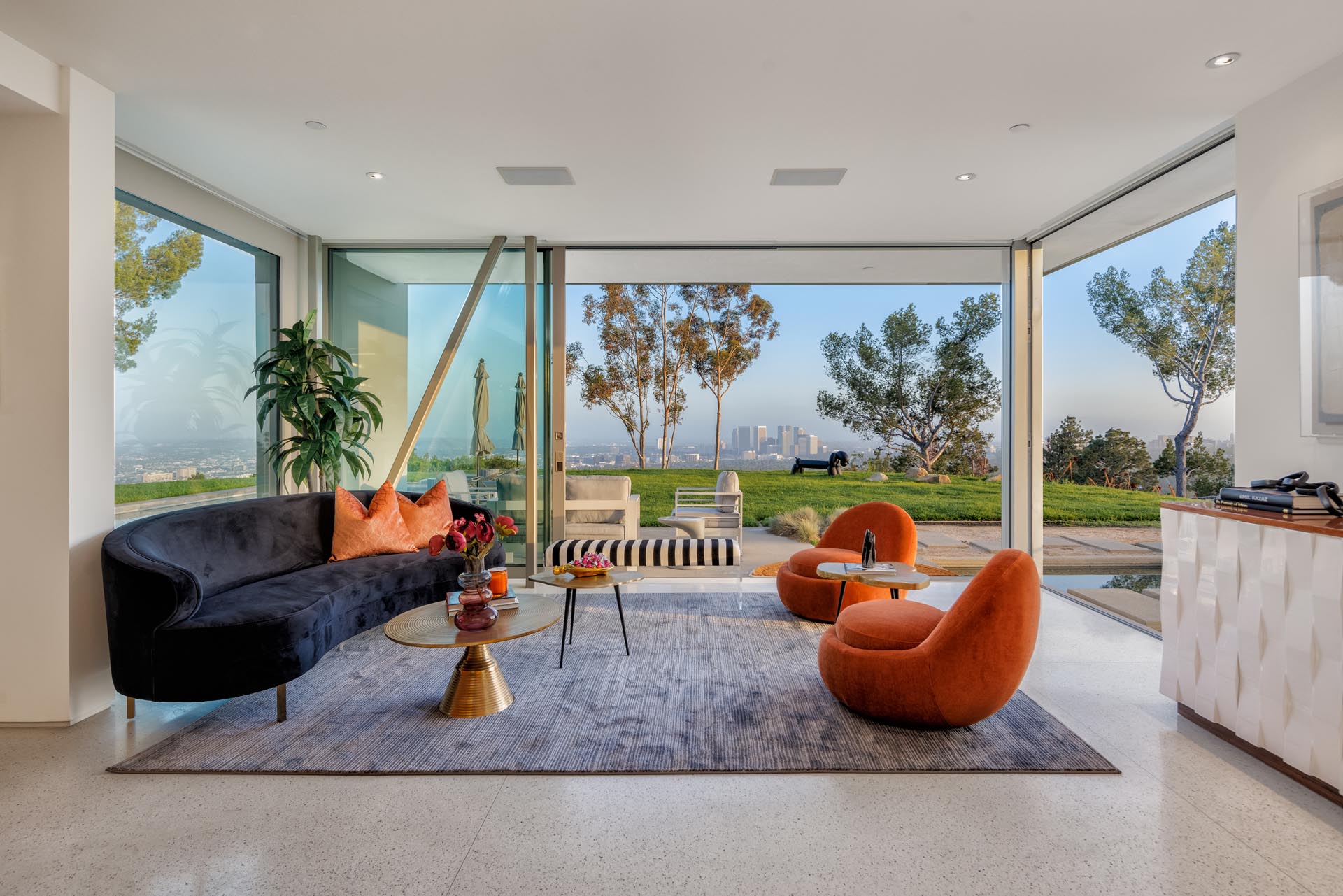 Sunlit living room opening to a terrace with city views